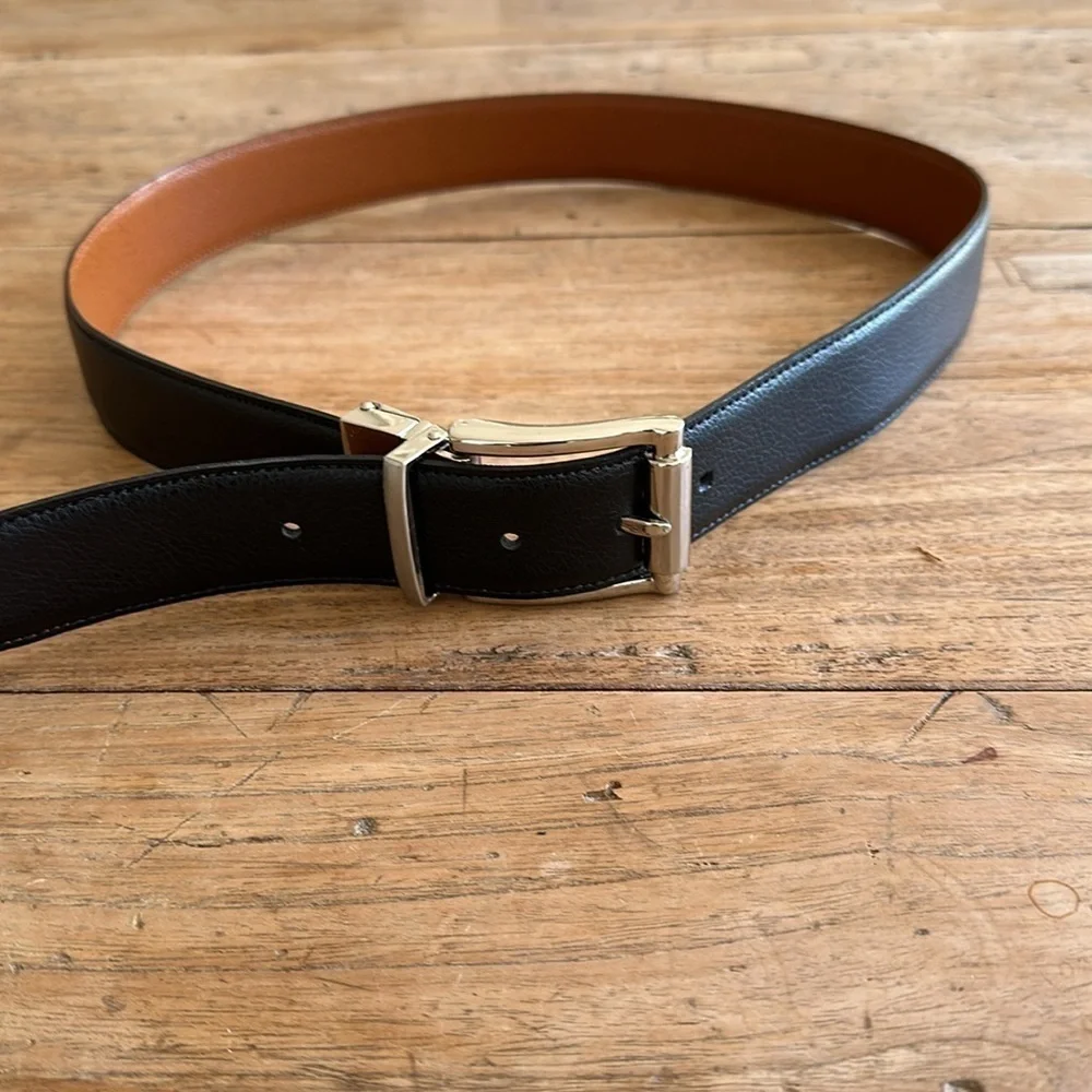 Reversible black and tan belt with silver buckle. Size 32.